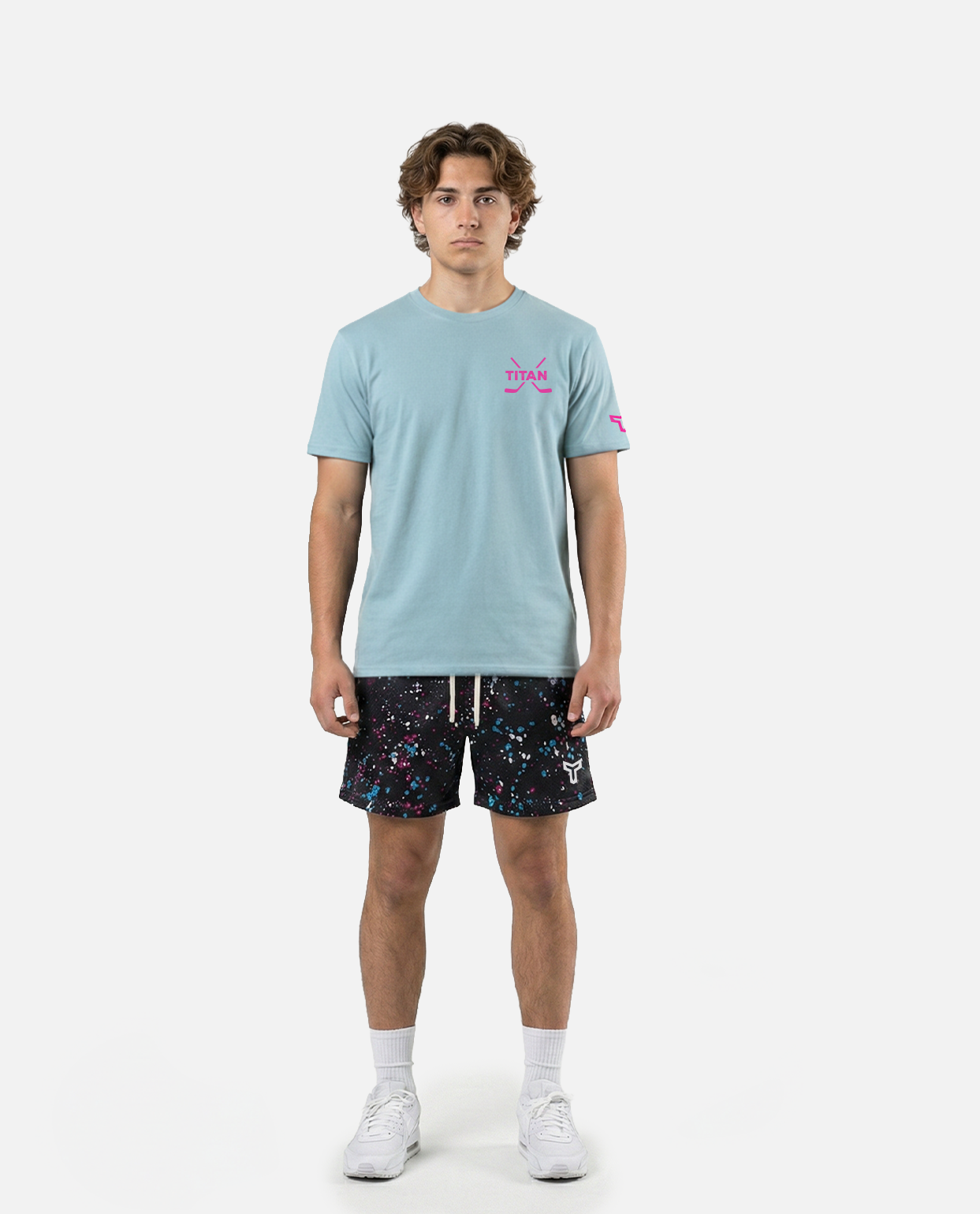 male model wearing Titan battlegear Black shorts with colorful speckles on a white background