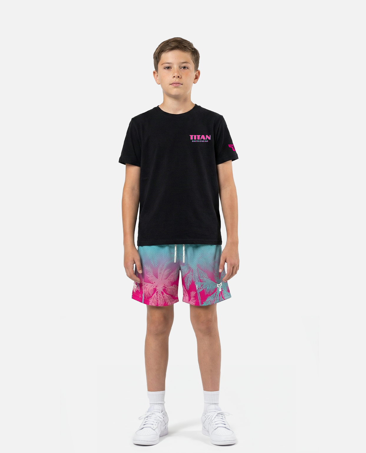 Child wearing a titan battlegear black t-shirt and colorful shorts on a white background