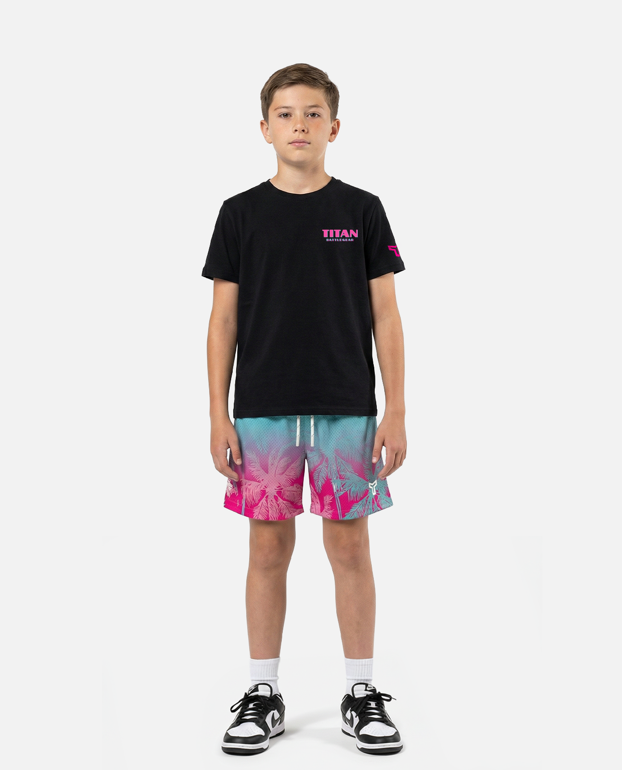 Child wearing a titan battlegear black t-shirt and colorful shorts on a white background